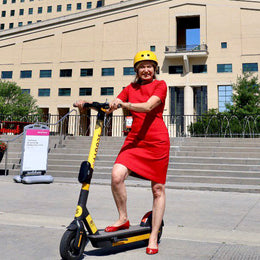 Bonnie Crombie posing on Scooty scooter with helmet