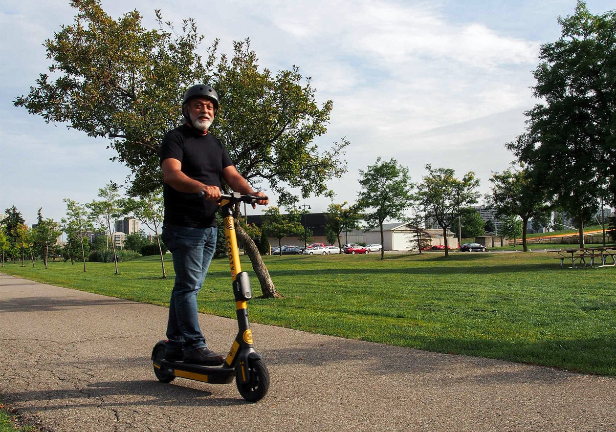 Person riding Scooty scooter on park path