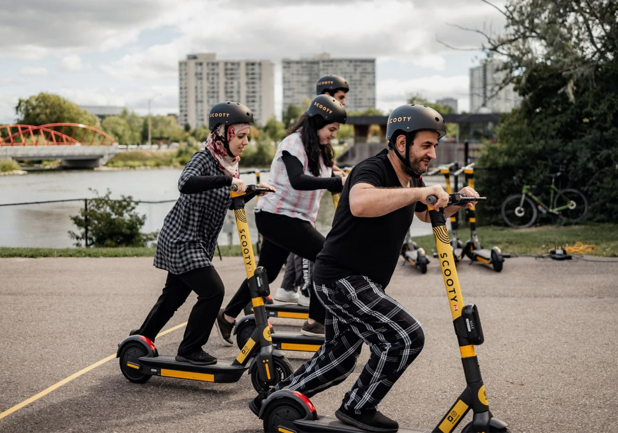 A group enjoying Scooty scooters by the waterfront